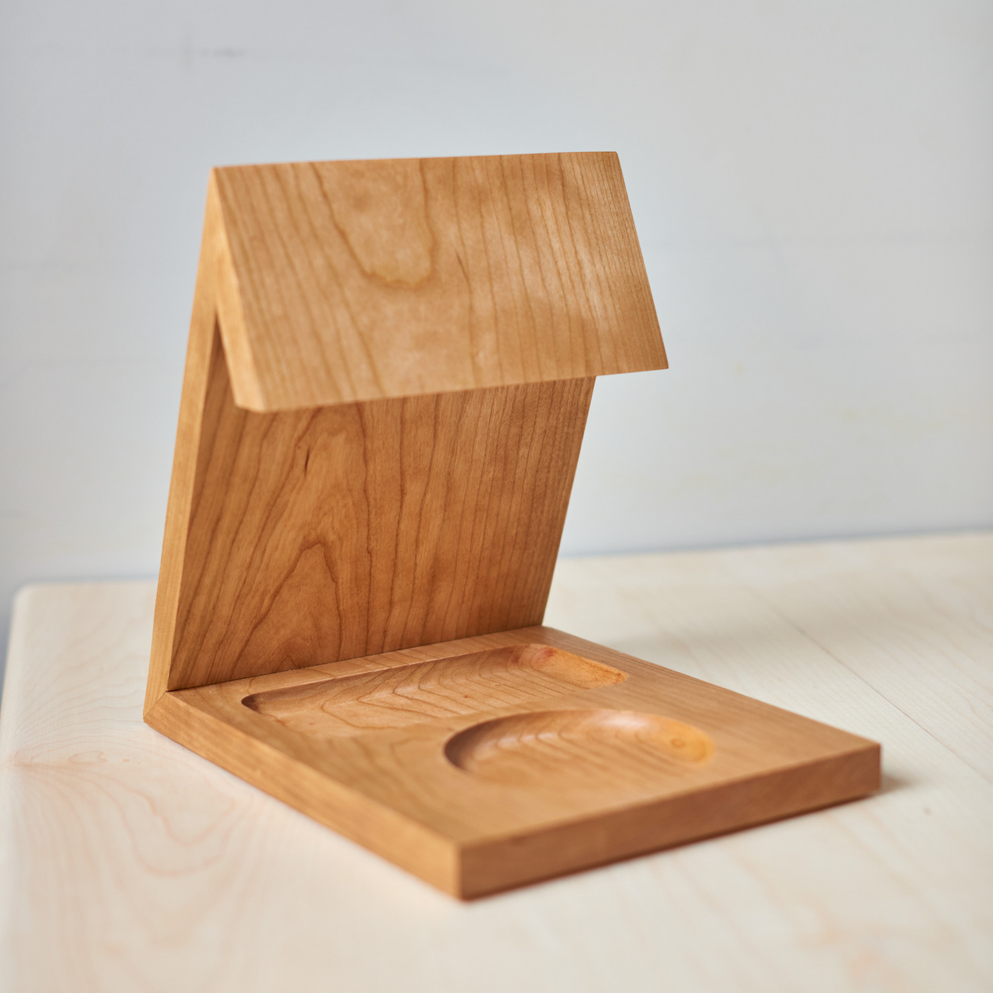A wooden book caddy rest your book, has a dedicated space for your favourite beverage, and a home for your phone, made out of beautiful cherry hardwood.