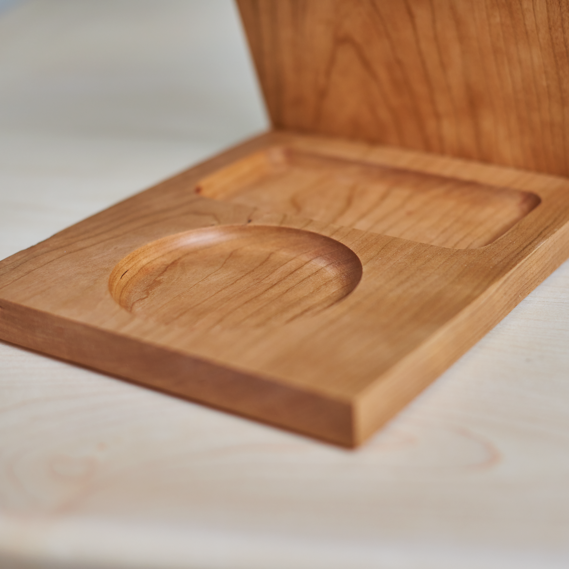 A wooden book caddy rest your book, has a dedicated space for your favourite beverage, and a home for your phone, made out of beautiful cherry hardwood.